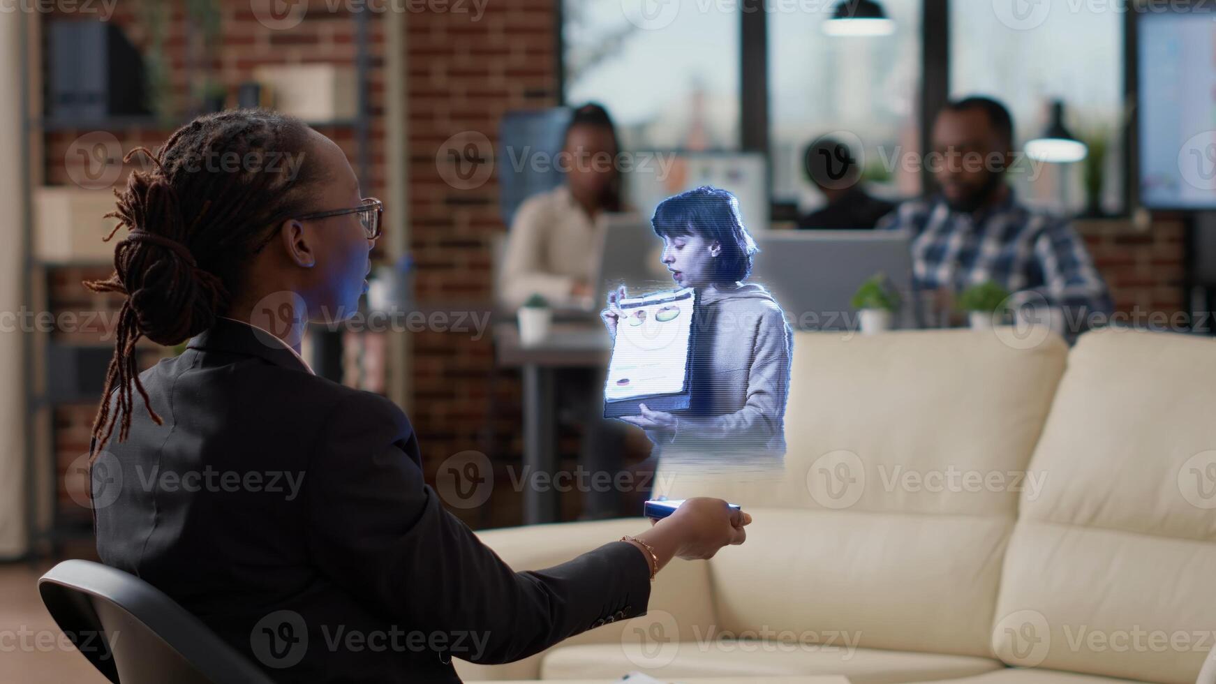 bipoc empleado en aumentado realidad teleconferencia reunión en alto tecnología oficina hablando con compañero de trabajo contador a lugar de trabajo escritorio en en línea videollamada con gerente utilizando holograma tecnología foto