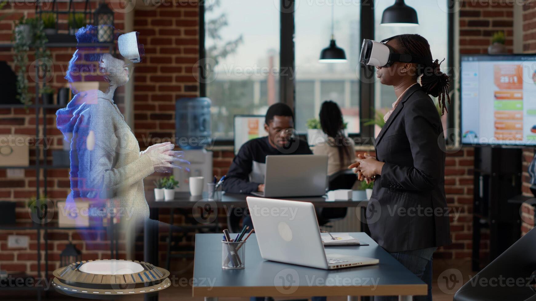 Employee wearing VR goggles with hologram supervisor. Businesswoman at high tech office desk computer watching virtual reality training video visualization of team leader explaining how to solve tasks photo