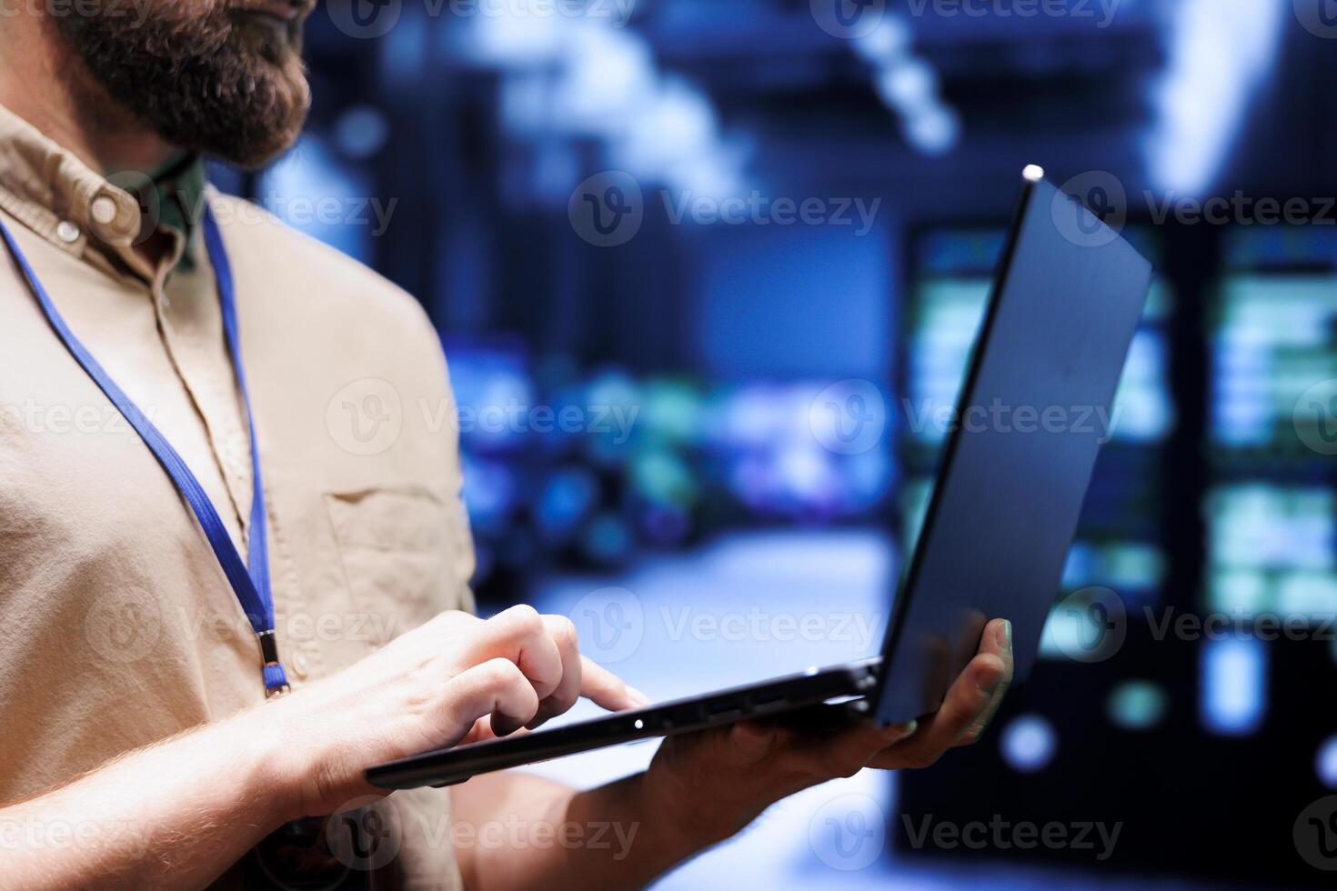 Close up of admin using laptop to check electronics in blockchain technology application specific integrated circuit server rig clusters. Focused employee checking for issues in crypto mining farm photo