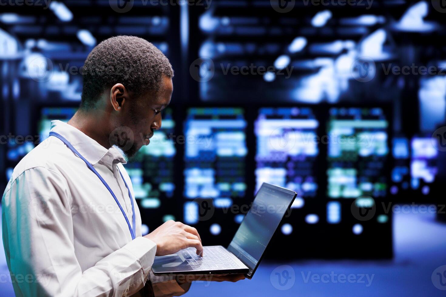 Programmer typing cloud computing service business disaster contingency plan on laptop to provide quick restoration of service, limiting downtime and minimizing interruptions to server hub operations photo