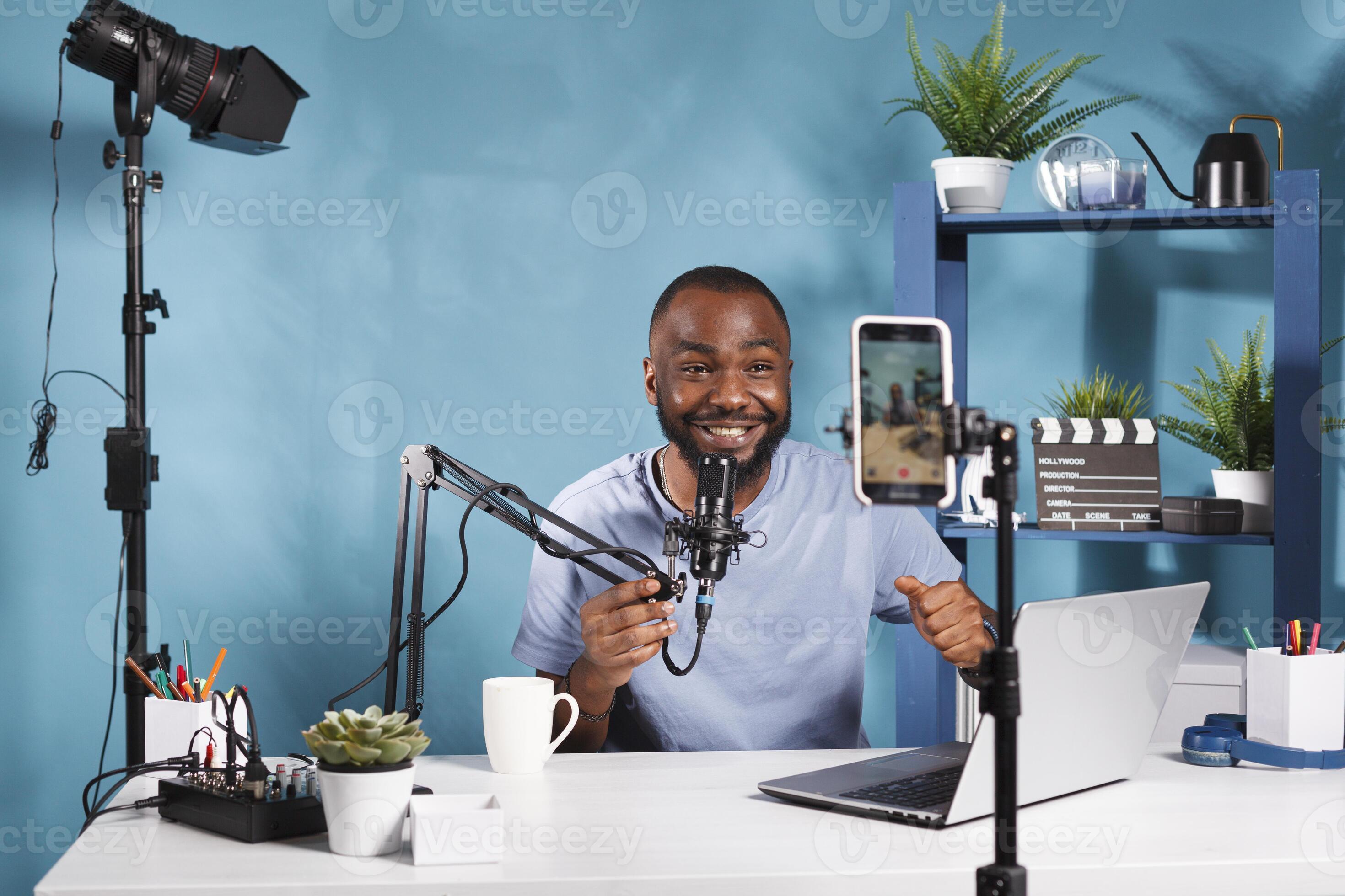 Smiling streamer speaking in microphone and looking at