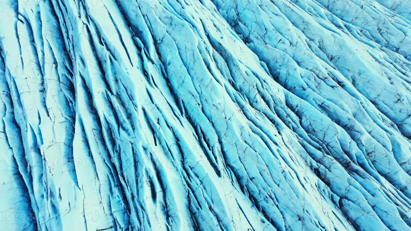 Aerial view of blue glacier blocks on vatnajokull ice cap in iceland, massive icebergs and crevasses creating natural scandinavian landscape. Spectacular ice rocks and glacier lagoon. Slow motion. photo