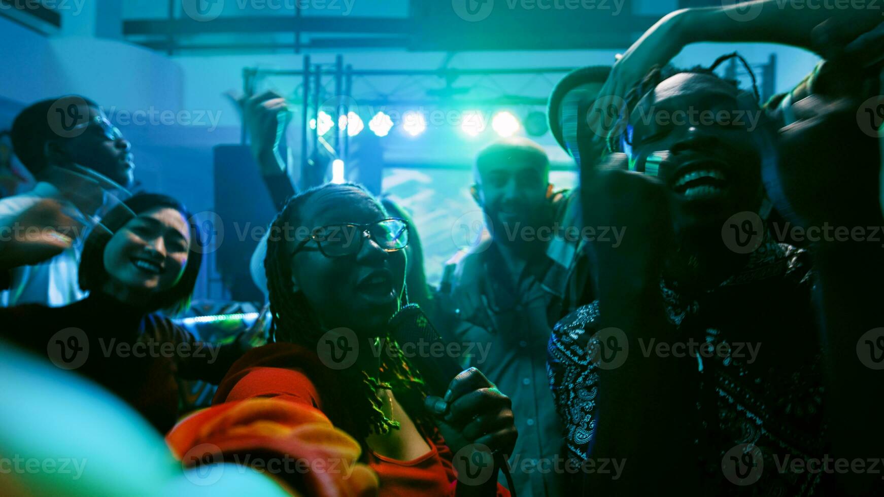 POV of adult recording vlog at nightclub, filming video while she parties with happy group of people. Young woman having fun at disco party with electronic music, dance event. Handheld shot. photo