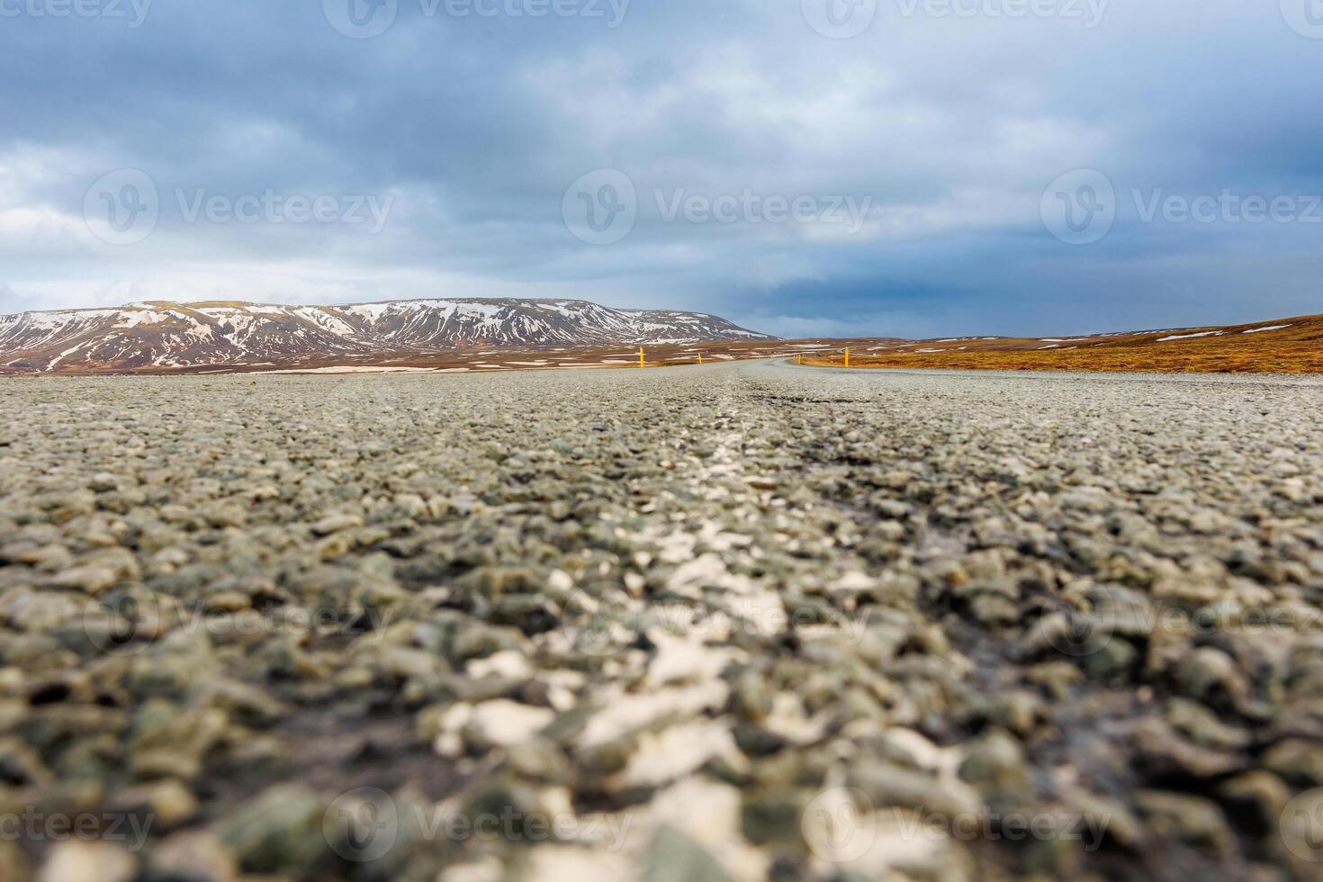 Long road through nordic landscape with lonely wayside, frosty farmland, and ice covered pastures in Iceland. Stunning overview of northern region and icy mountains, scandinavian highway. photo