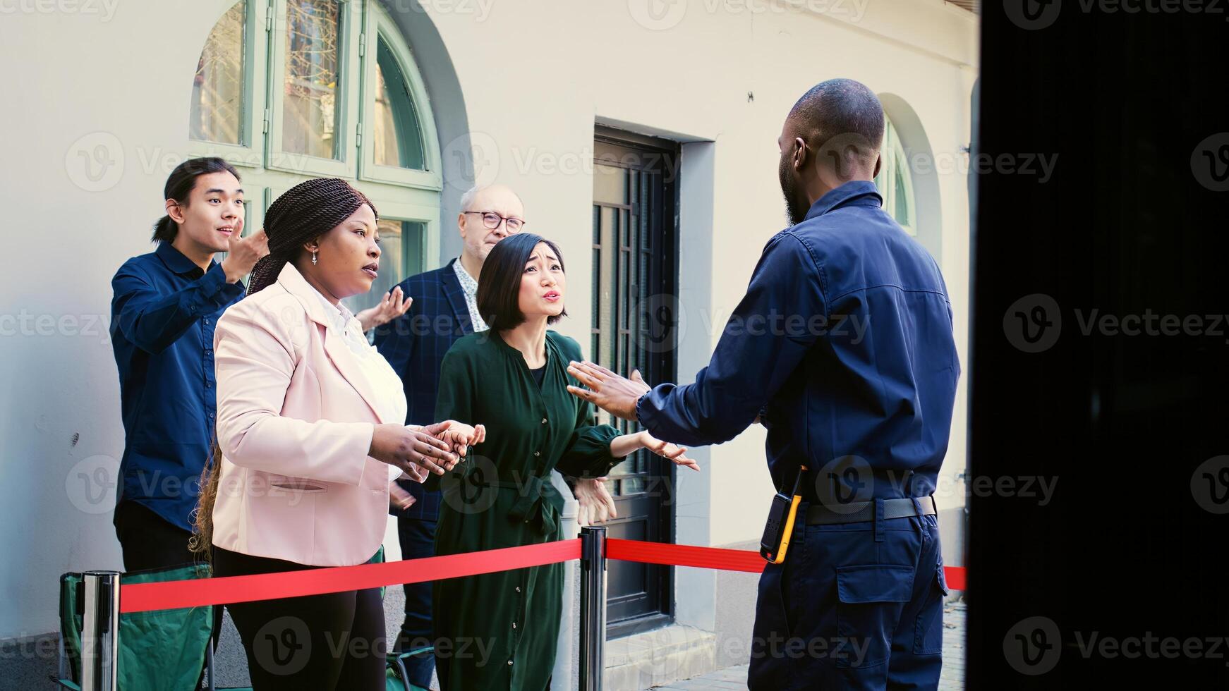 Shoppers arguing with security officer, waiting for black friday seasonal sales outside clothing store. Crazy anxious mall clients feeling tired of waiting in line at shopping center. photo