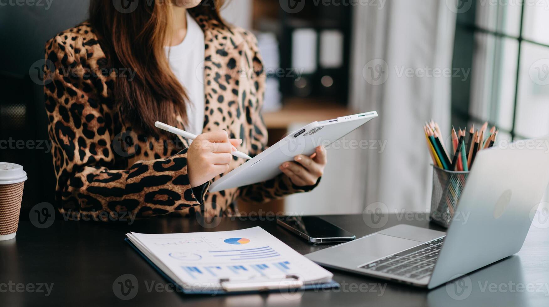 business documents on office table with smart phone and digital tablet and graph financial and woman working at office photo