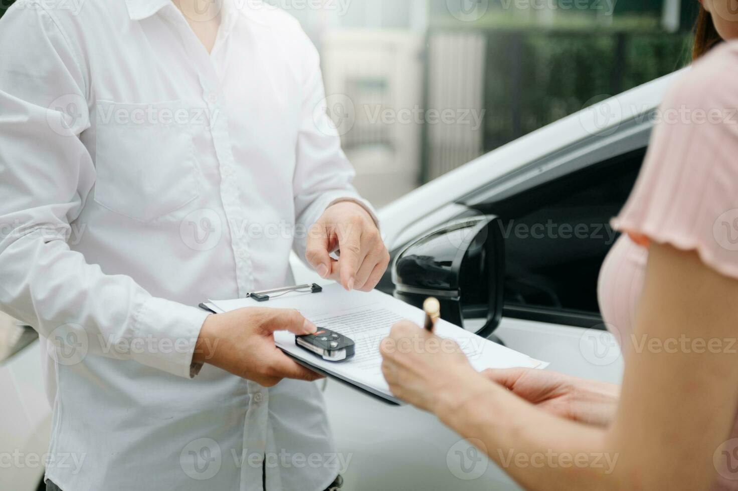 Automotive business, car sale or rental concept Customer with car dealer agent making deal and signing on agreement document contract in auto showroom photo