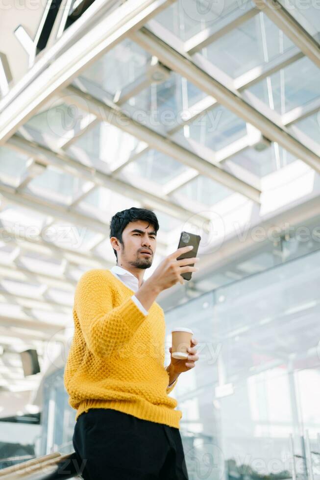 Successful businessman works outdoors near the office holds a tablet in sun light photo