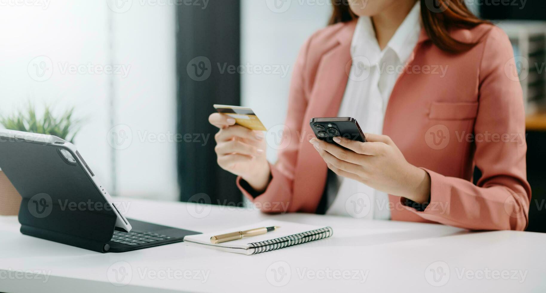 Woman using smart phone for mobile payments online shopping, omni channel, sitting on table, virtual icons graphics interface screen photo