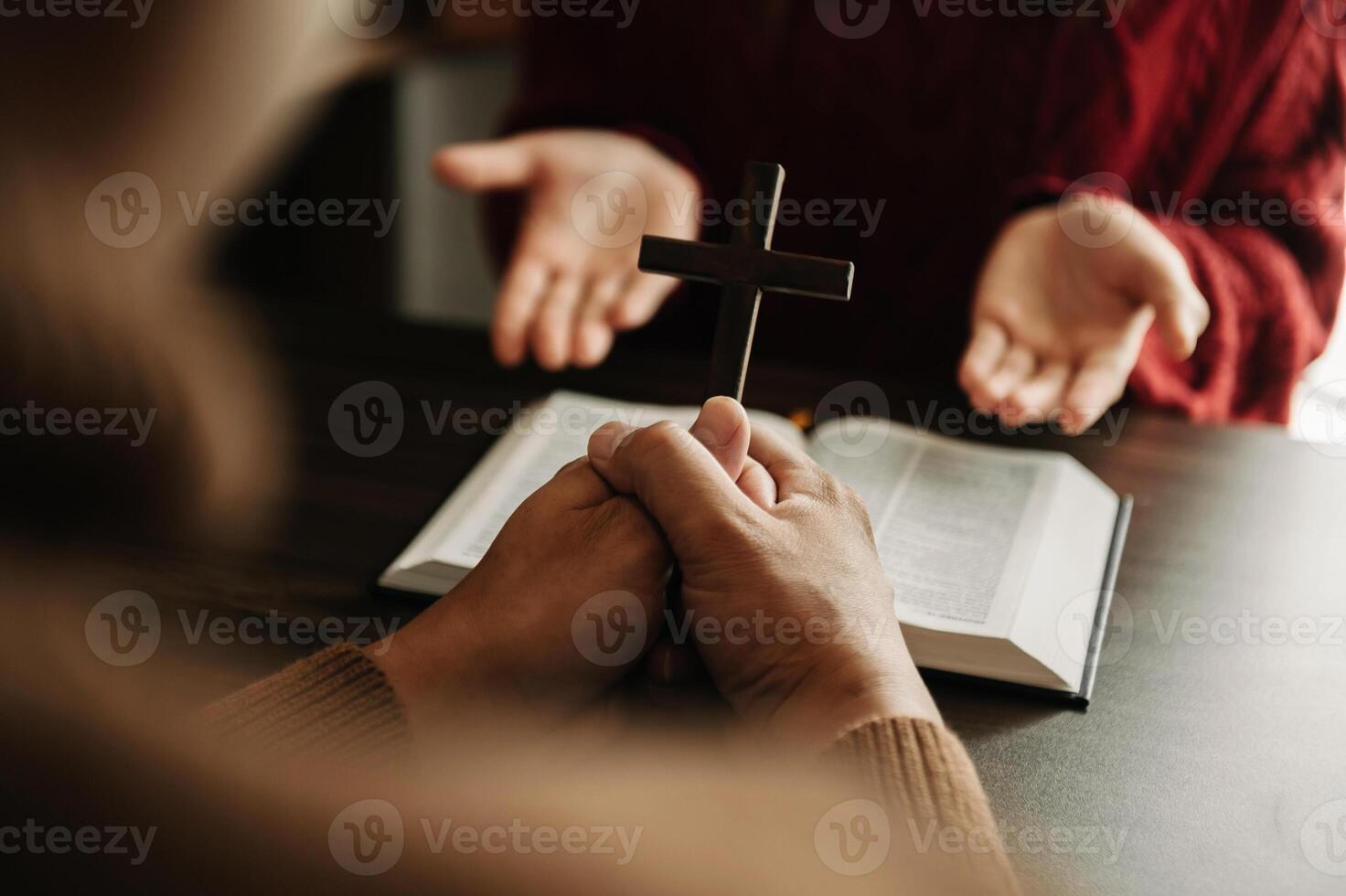 Two people reading and study bible in home and pray together.Studying the Word Of God With Friends. in sun light photo