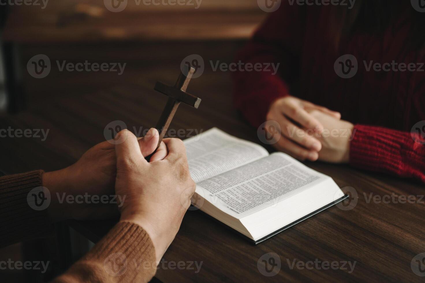Two people reading and study bible in home and pray together.Studying the Word Of God With Friends. in sun light photo
