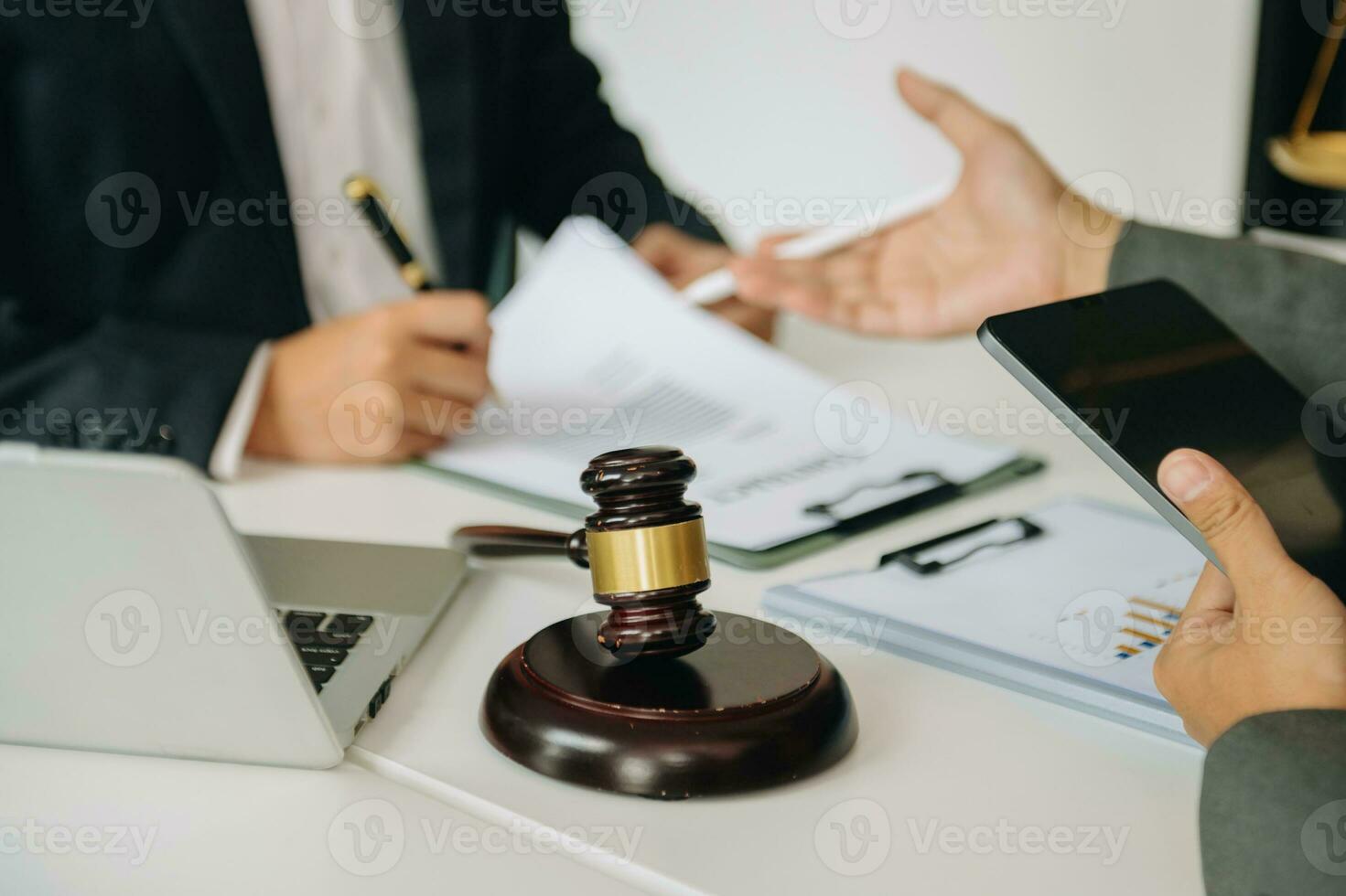 justice and law concept.law theme wooden desk, books, balance. Male judge in a courtroom the gavel,working with digital tablet computer on desk photo