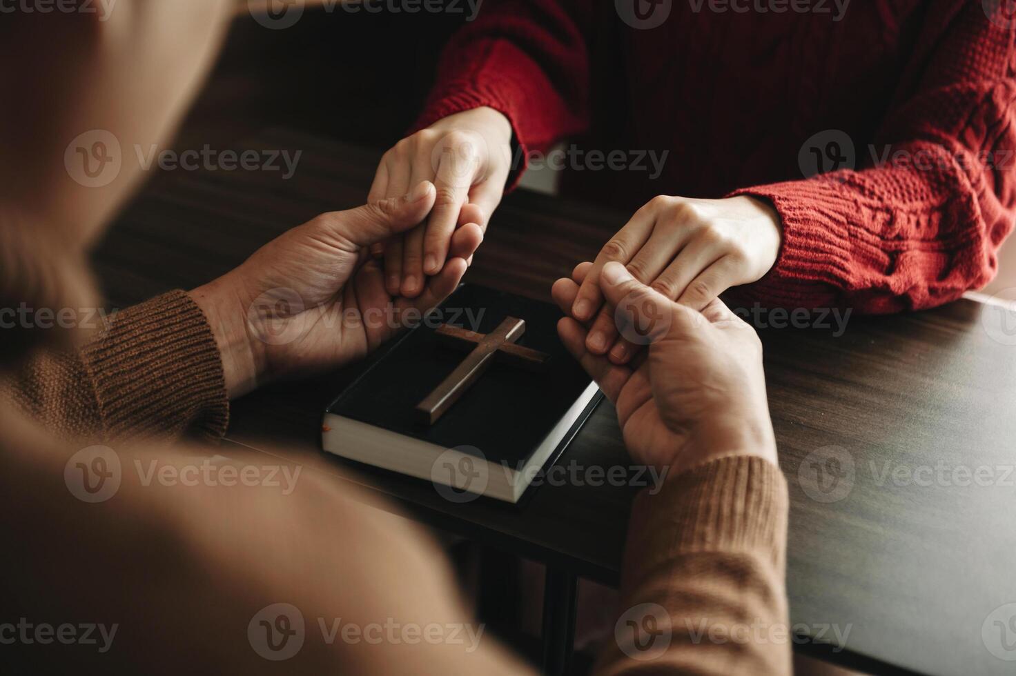 Two people reading and study bible in home and pray together.Studying the Word Of God With Friends. in sun light photo