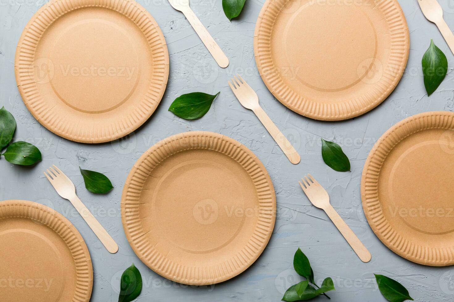set of empty reusable disposable eco-friendly plates, cups, utensils on light white colored table background. top view. Biodegradable craft dishes. Recycling concept. Close-up photo
