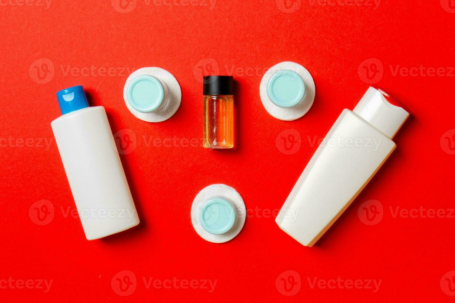 Top view composition of small travelling bottles and jars for cosmetic products on colored background. Facial skin care concept with copy space for your design photo