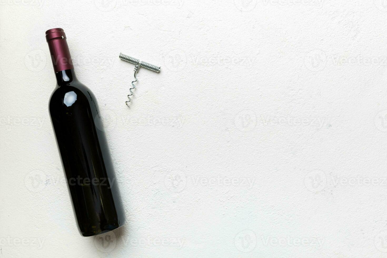 One Bottle of red wine with corkscrew on colored table. Flat lay, top view wth copy space photo