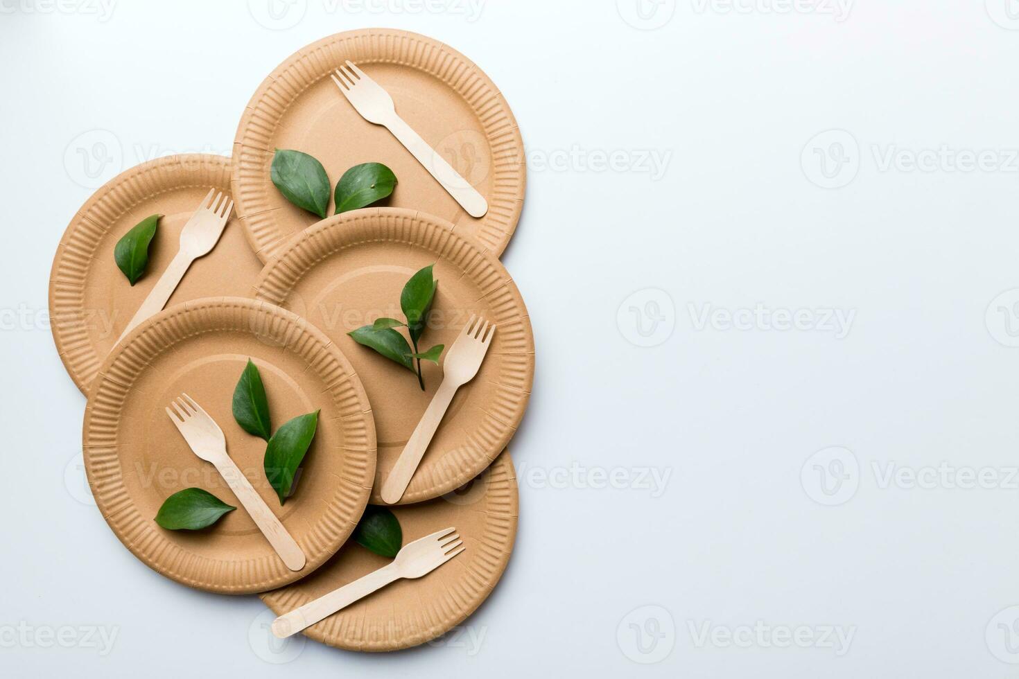 set of empty reusable disposable eco-friendly plates, cups, utensils on light white colored table background. top view. Biodegradable craft dishes. Recycling concept. Close-up photo