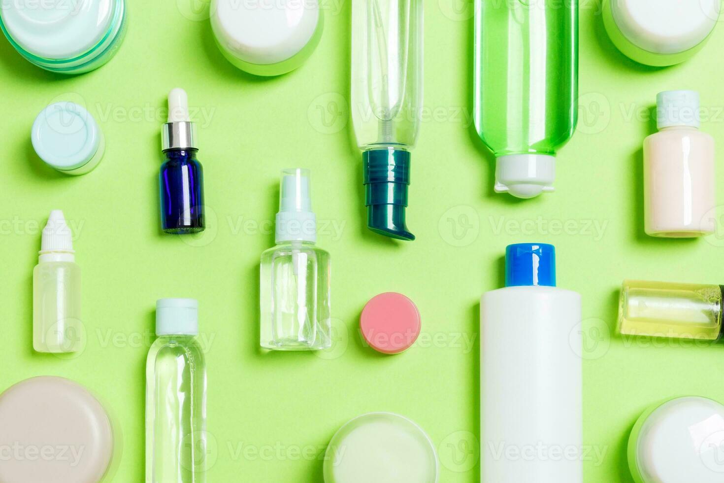 Group of plastic bodycare bottle Flat lay composition with cosmetic products on green background empty space for you design. Set of White Cosmetic containers, top view with copy space photo