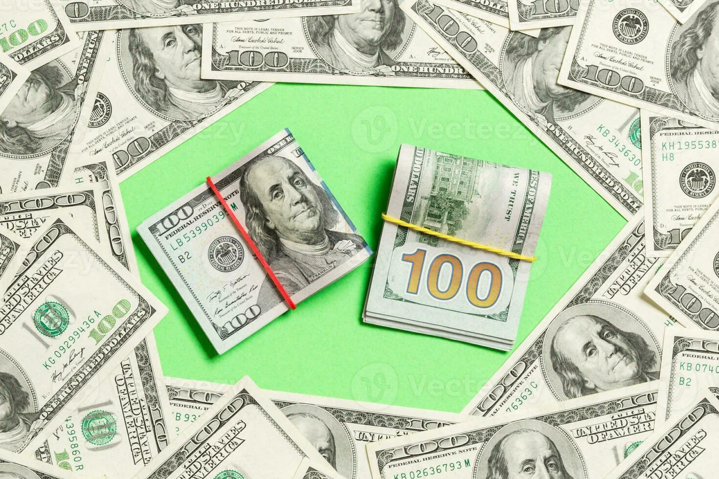 Frame of one hundred dollar bills with stack of money in the middle. Top view of business concept on green background with copy space photo