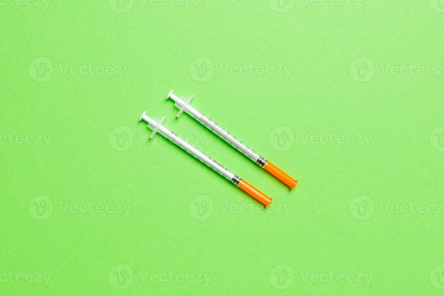 Top view of two insulin syringe at colorful background with copy space. High level of glucose concept photo