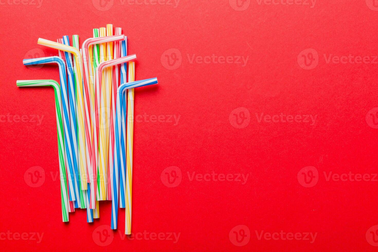 Heap of colorful plastic drinking straws on Colored background, flat lay. Copy Space for text photo