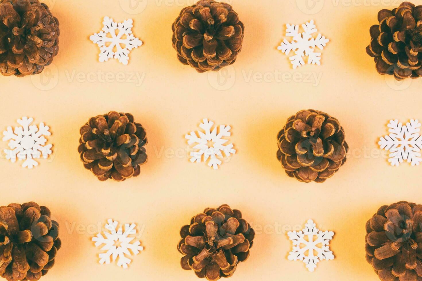 Top view of holiday composition made of pine cones and white snowflakes on colorful background. Winter time and Christmas concept with copy space photo