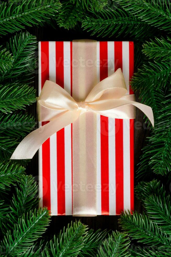 Top view of Christmas gift box on fir tree background. Time for holiday concept with copy space photo