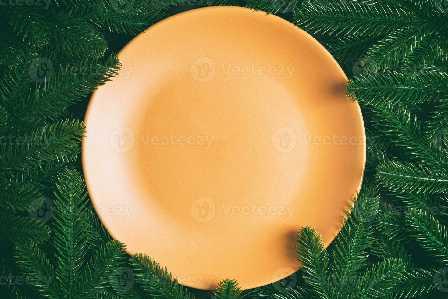 Top view holiday plate among green fir tree branches. Christmas dinner with copy space photo