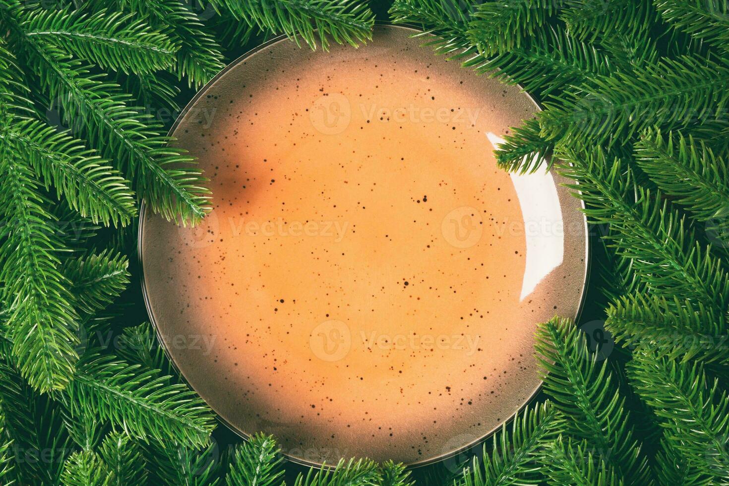Top view holiday plate among green fir tree branches. Christmas dinner with copy space photo
