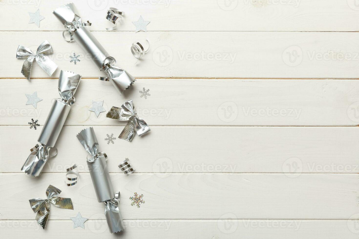 Christmas crackers with shiny confetti on color background, top view, copy space photo