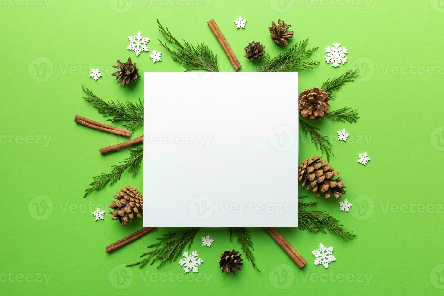 Flat lay Christmas composition. square Paper blank, pine tree branches, christmas decorations on Colored background. Top view, copy space for text photo