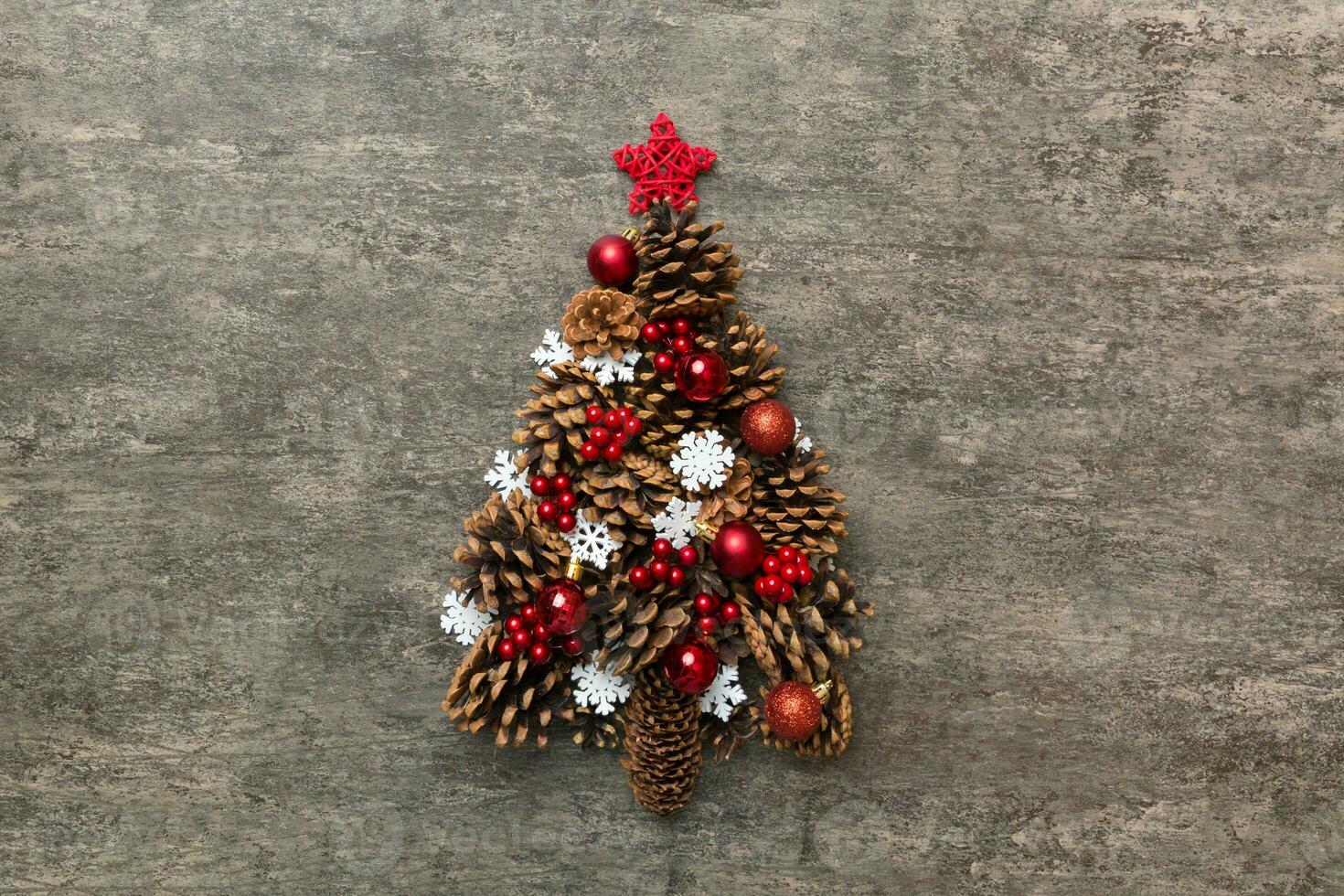 Christmas tree made from natural cones on colored background, view from above. New Year minimal concept with copy space photo