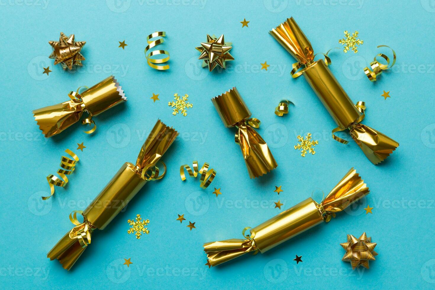 Christmas crackers with shiny confetti on color background, top view, copy space photo