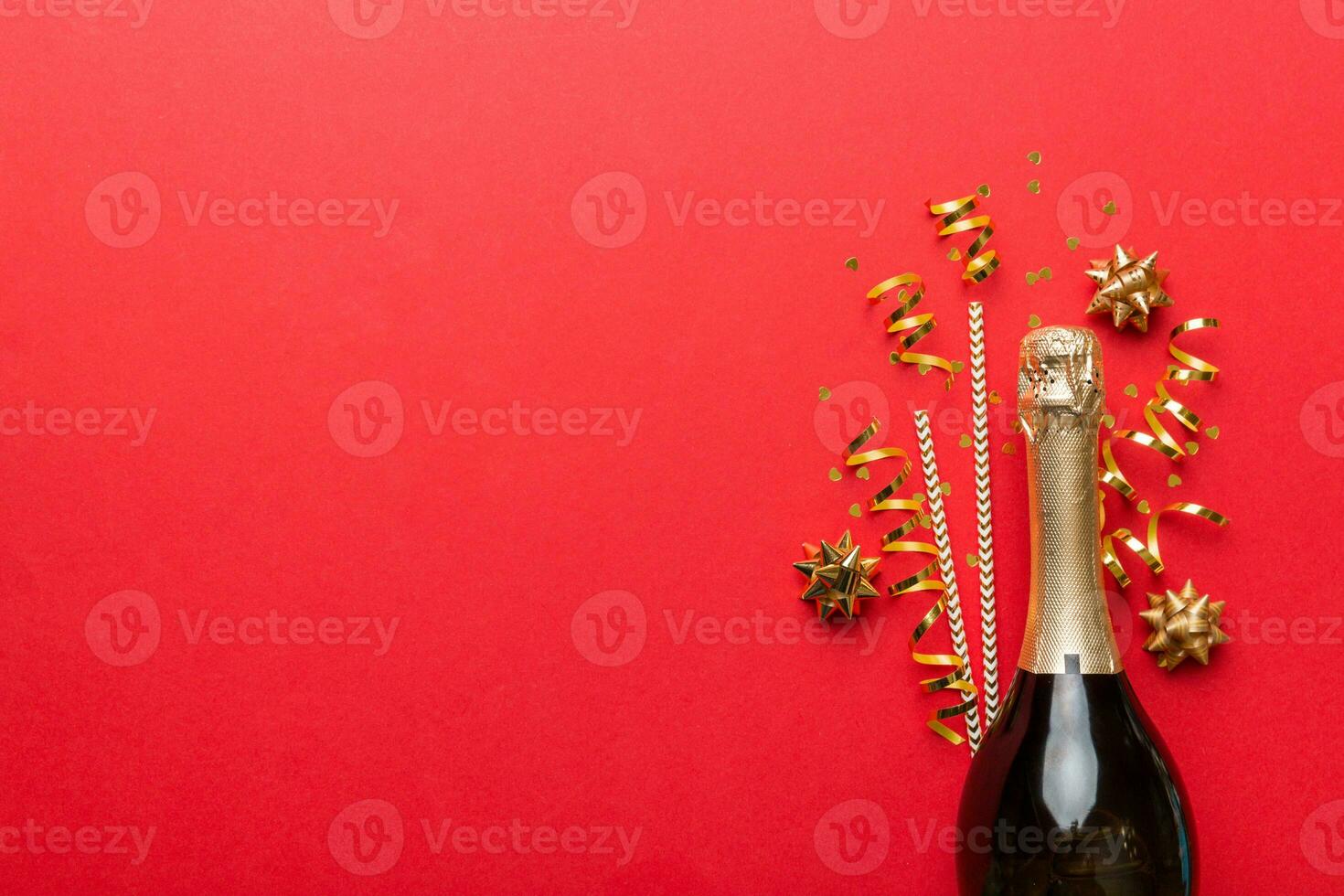 bottle of champagne with glasses and colorful confetti on colored background. top view flay lay photo