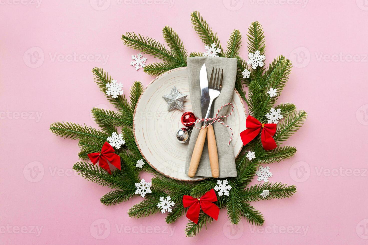Christmas table place setting with christmas decor and plates, kine, fork and spoon. Christmas holiday background. Top view photo