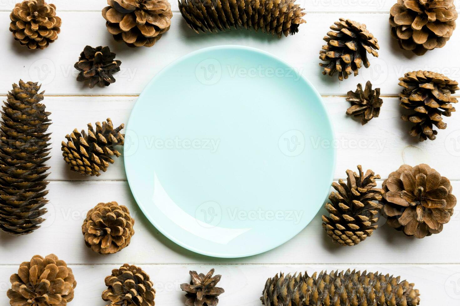 Top view of festive plate with pine cones on wooden background. New Year dinner concept photo