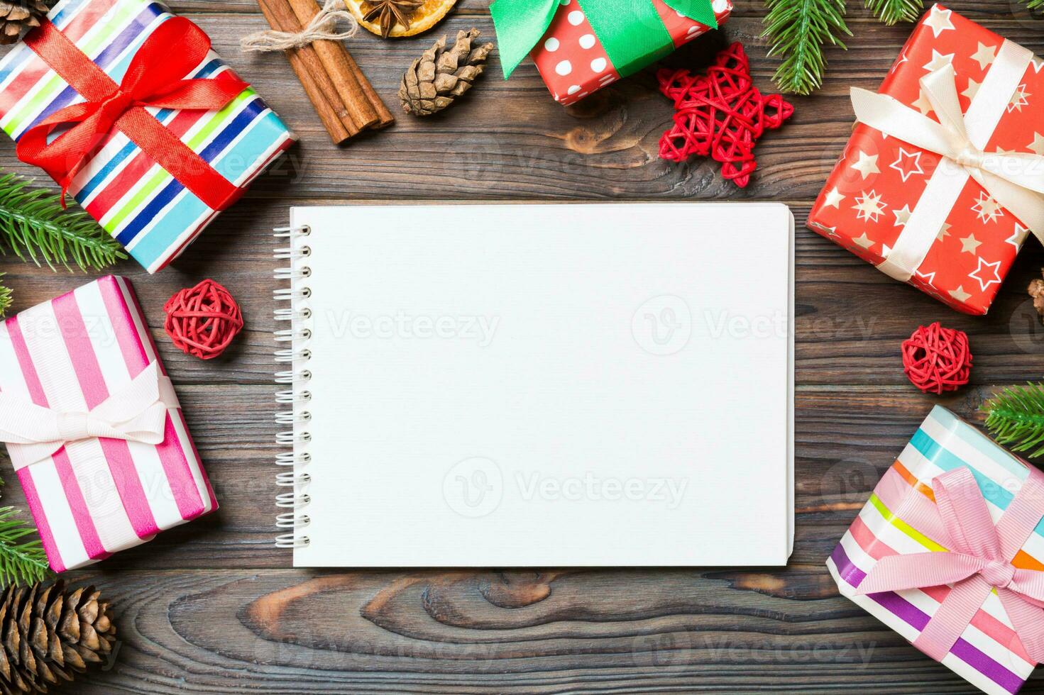 Top view of a notebook on wooden holiday background made of fir tree and New Year decorations. Christmas time concept photo