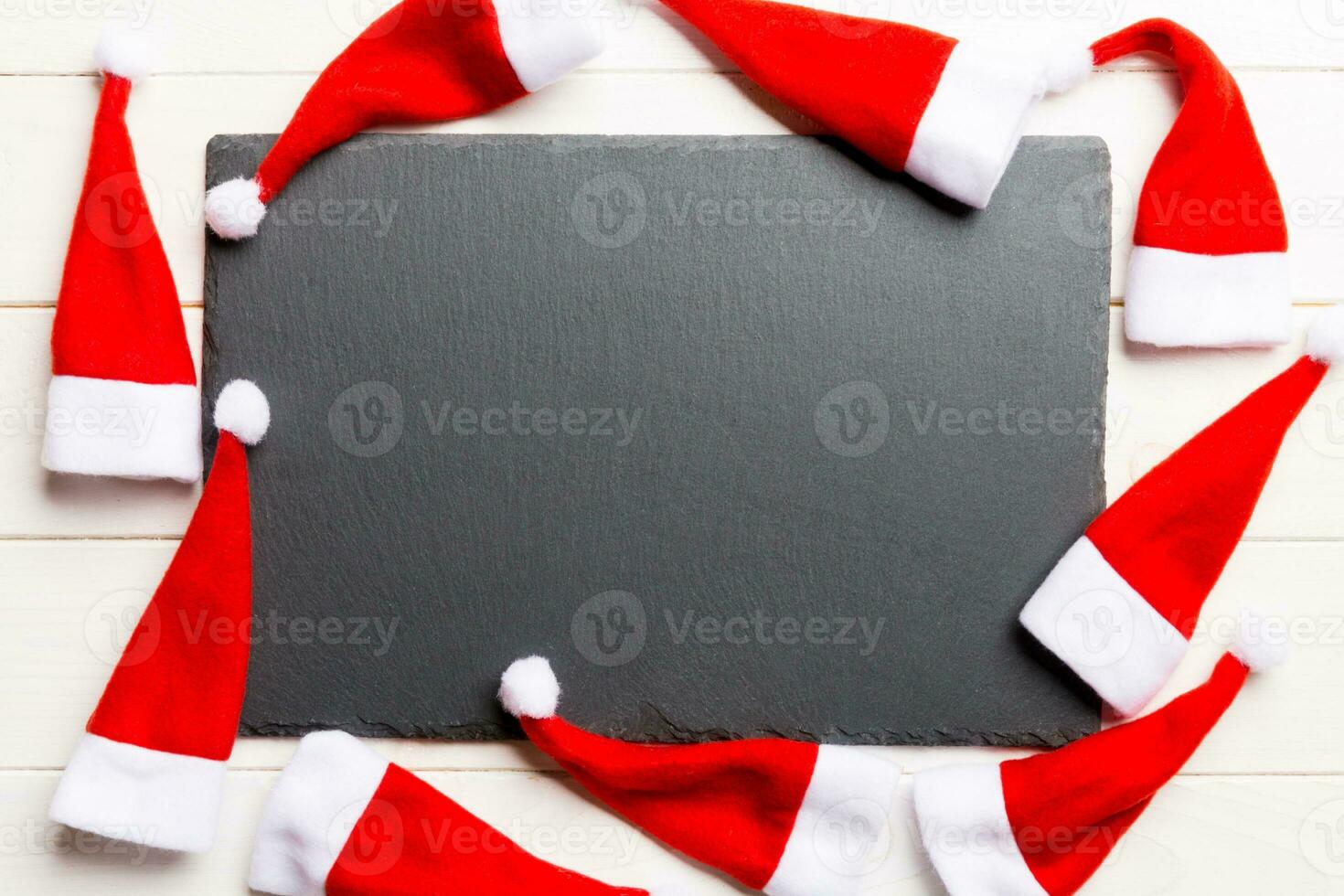 Festive set of plate decorated with Santa Claus hat on wooden background. Top view christmas dinner concept photo