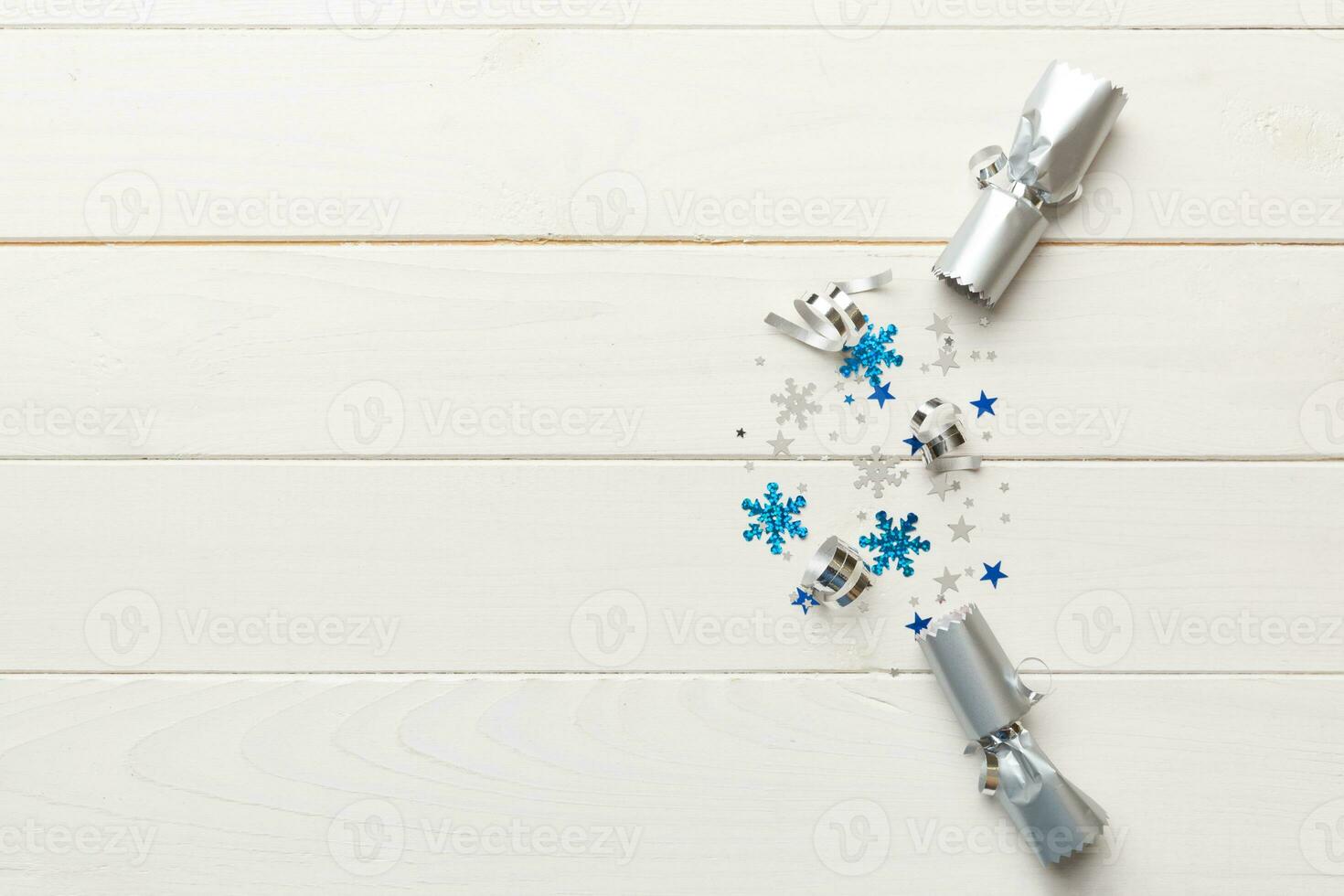 Christmas crackers with shiny confetti on color background, top view, copy space photo