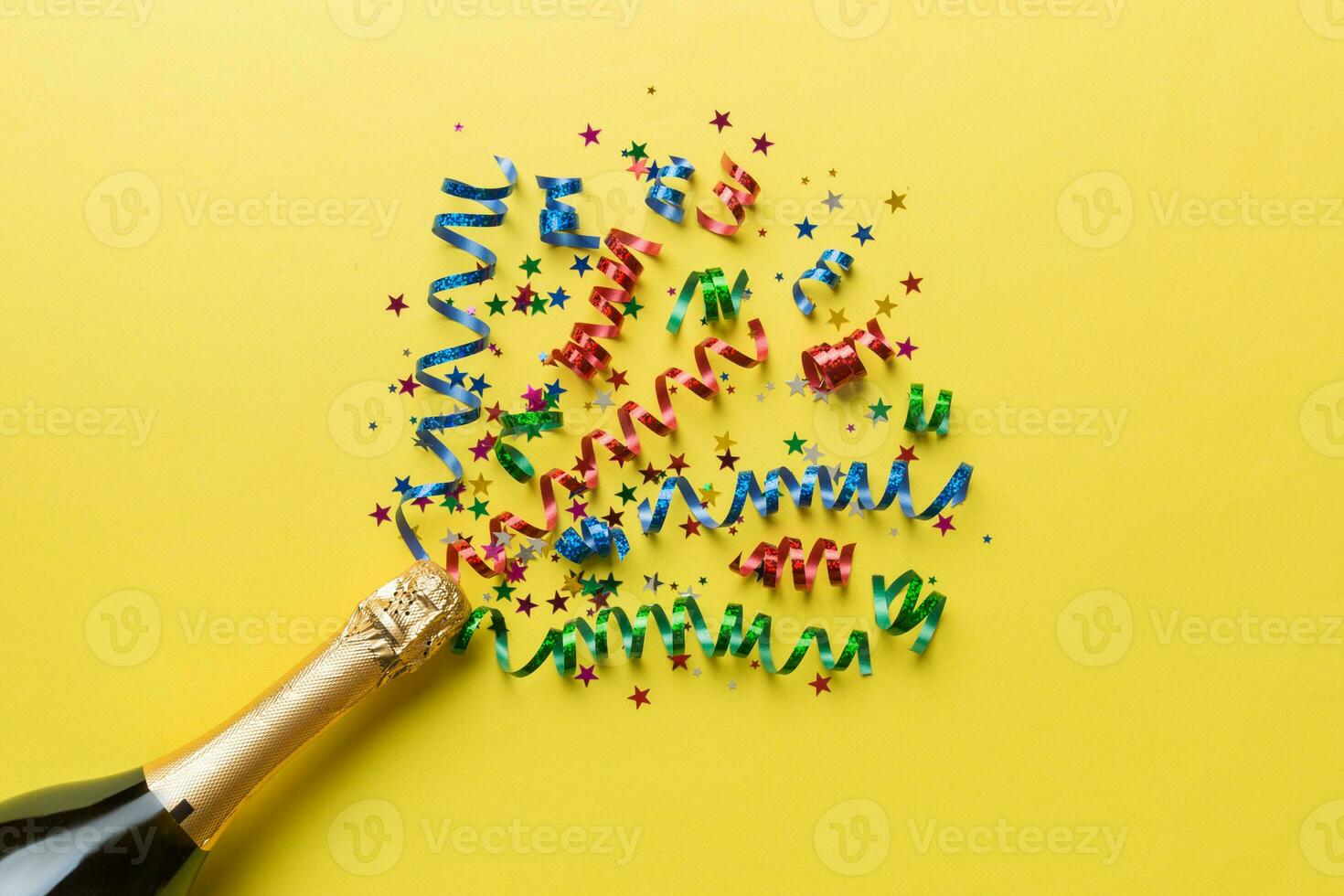 Creative flat lay composition with bottle of champagne and space for text on color background. Champagne bottle with colorful party streamers. holiday or christmas concept photo