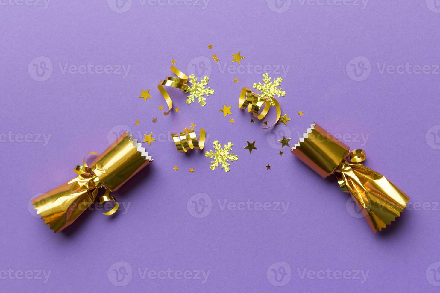 Christmas crackers with shiny confetti on color background, top view, copy space photo