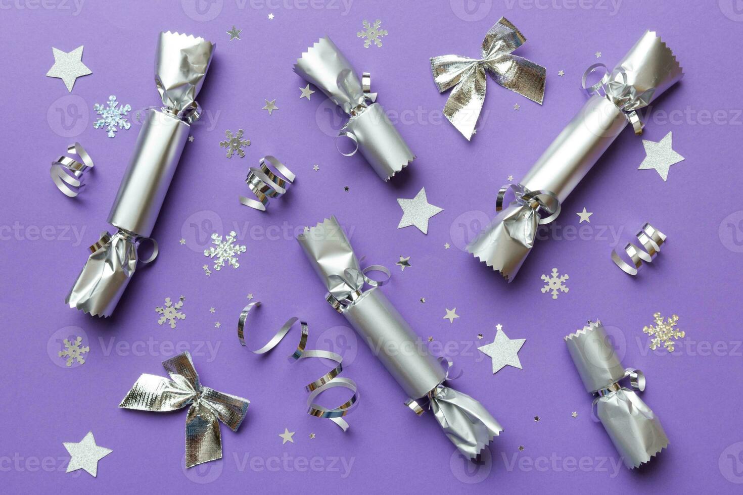Christmas crackers with shiny confetti on color background, top view, copy space photo