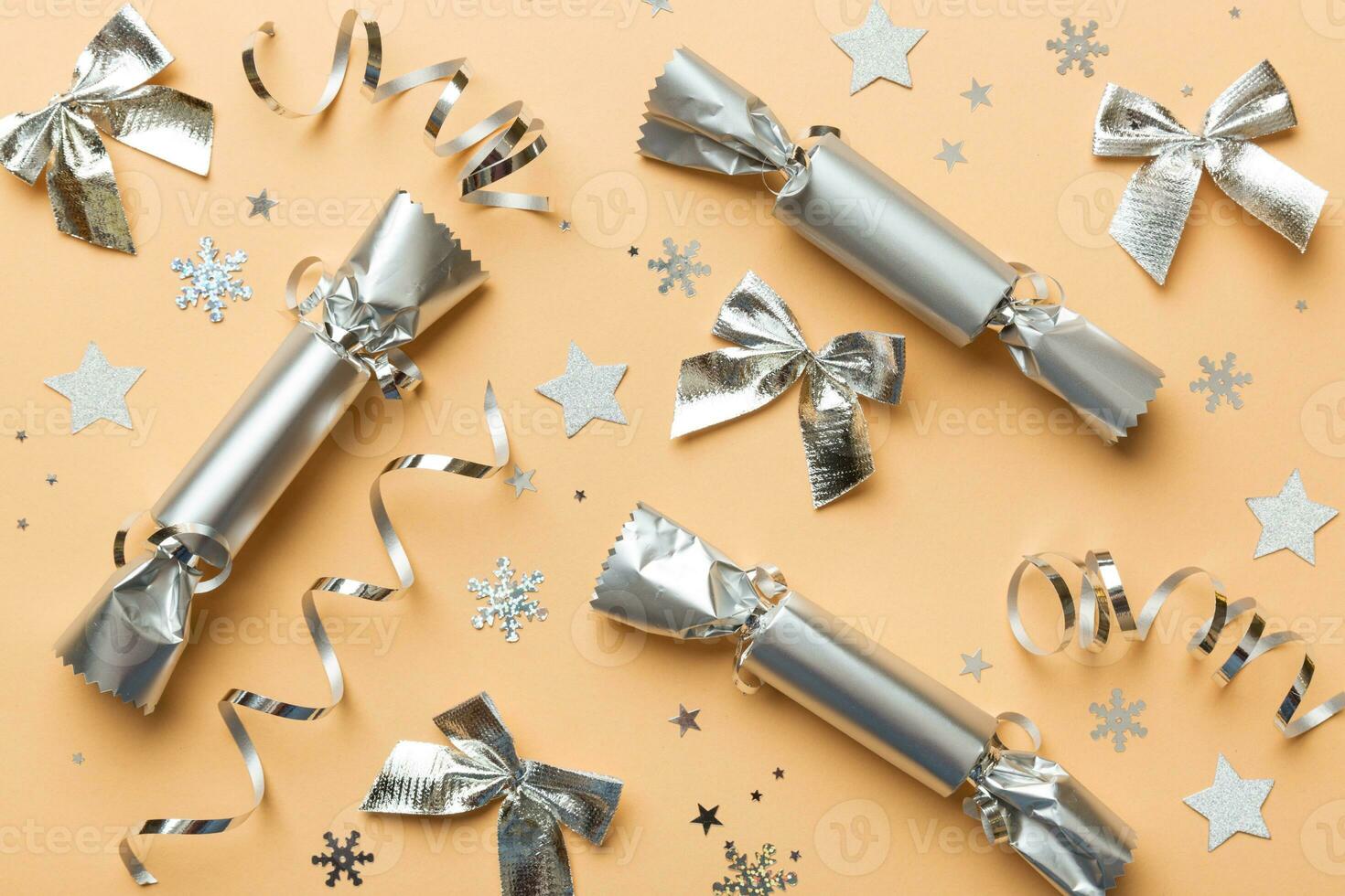 Christmas crackers with shiny confetti on color background, top view, copy space photo