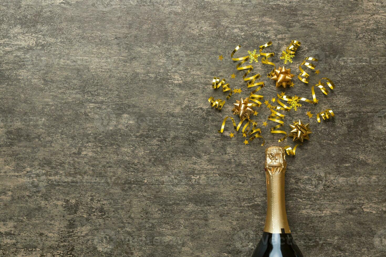 Creative flat lay composition with bottle of champagne and space for text on color background. Champagne bottle with colorful party streamers. holiday or christmas concept photo
