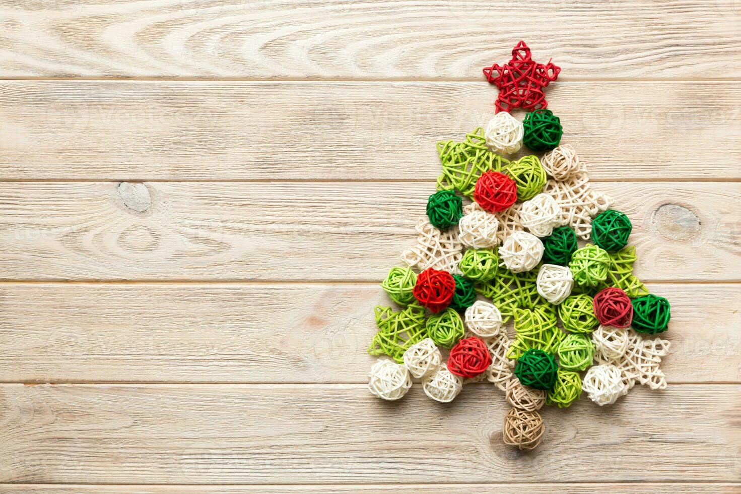 Christmas tree made from colored handmade ball decoration on colored background, view from above. New Year minimal concept with copy space photo