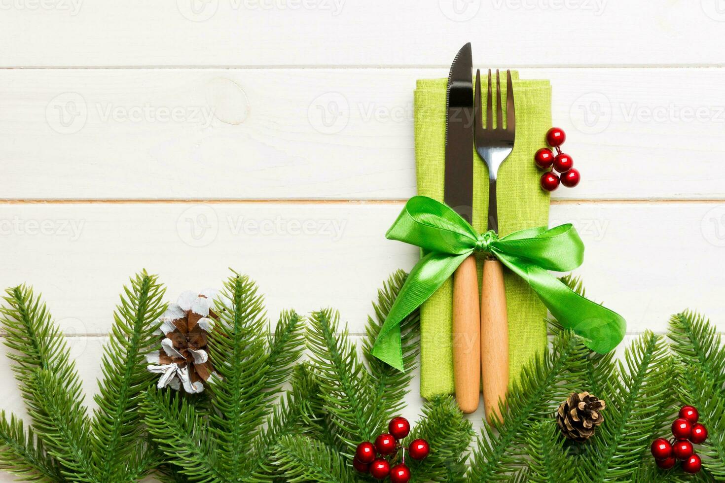 Top view of festive cutlery on new year wooden background. Christmas decorations with empty space for your design. Holiday dinner concept photo