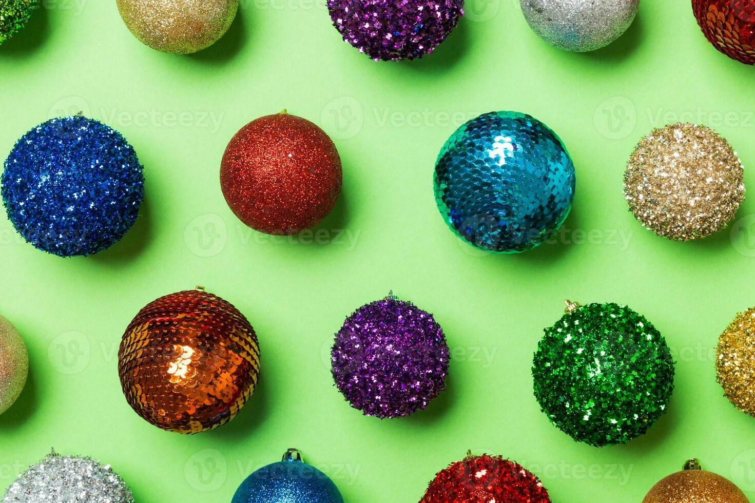 Top view of colorful Christmas balls on green background. New Year time concept photo
