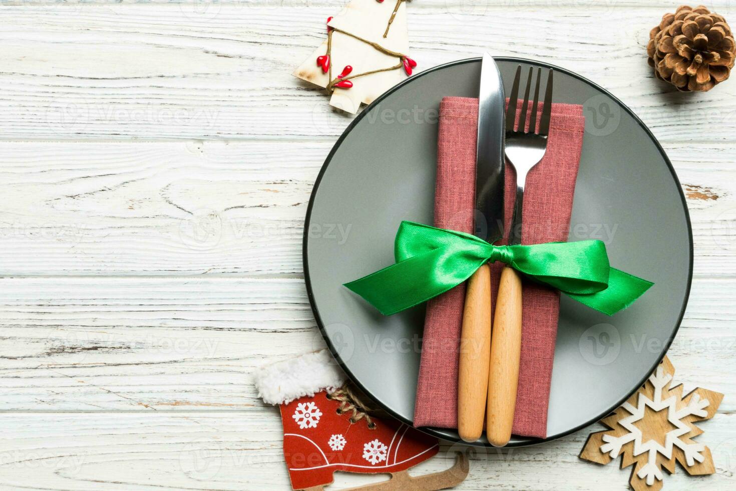 Holiday composition of Christmas dinner on wooden background. Top view of plate, utensil and festive decorations. New Year Advent concept with copy space photo