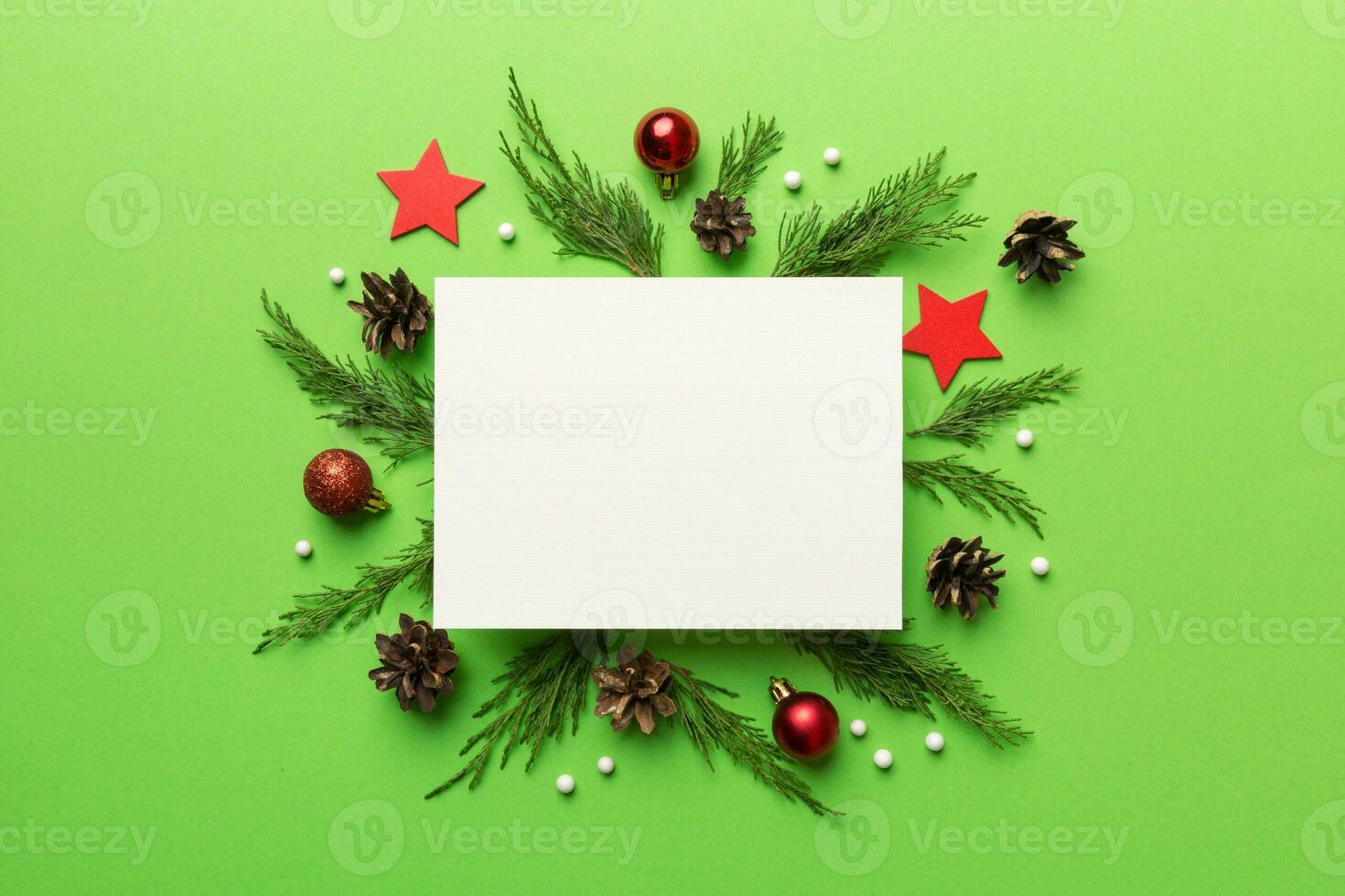 Flat lay Christmas composition. square Paper blank, pine tree branches, christmas decorations on Colored background. Top view, copy space for text photo