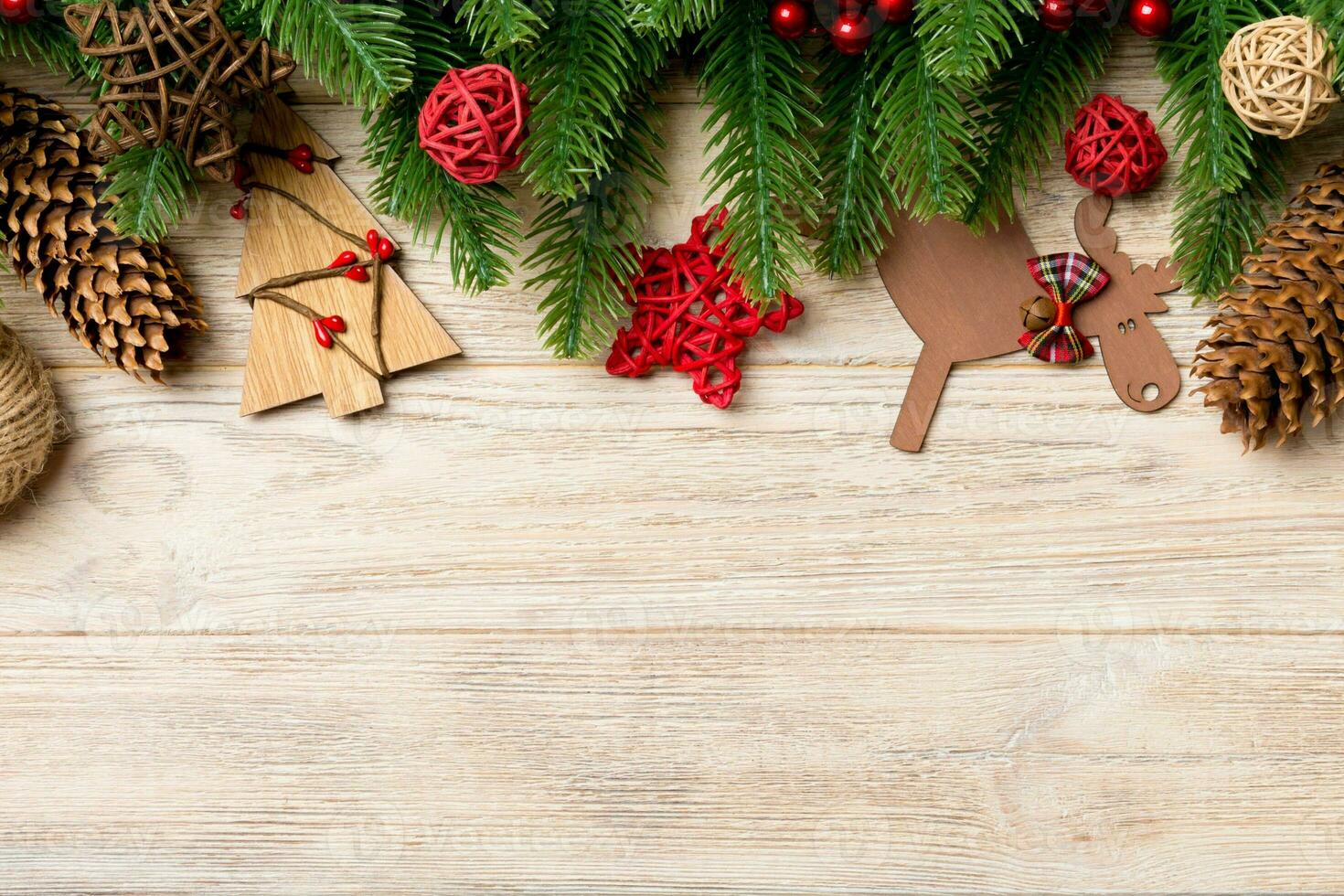 Top view of Christmas toys, decorations and fir tree branches on wooden background. New Year holiday concept with copy space photo